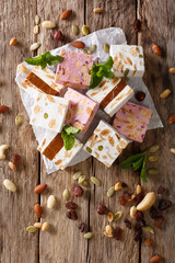 Sweet nougat with nuts, decorated with mint closeup on the table. vertical top view