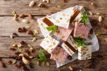 Sweet nougat with nuts, decorated with mint closeup on the table. Horizontal top view