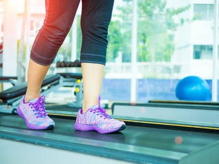 Woman step and running on the treadmill in the gym fitness