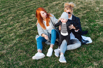 Mom and aunt play with a boy in the Park