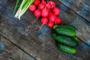 Radish cucumbers and green onion on wooden table. Top view