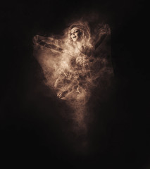 Dancer from smoke on the dark background