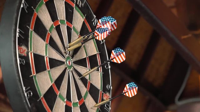 Dartboard with american flag on darts thrown at it, bad thrower