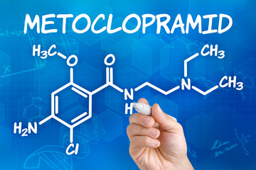 Hand mit Stift zeichnet chemische Strukturformel von Metoclopramid