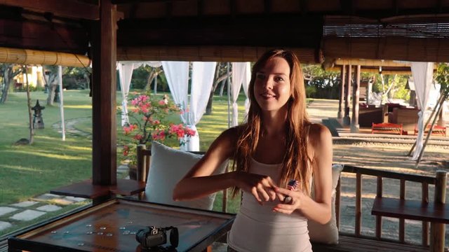 Young caucasian woman throwing darts in a beach club at sunset