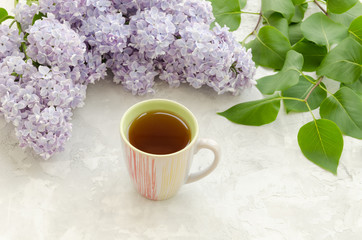 Cup of tea with lilac flowers