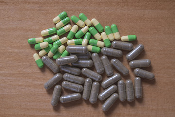 Drug pills in various shape and sizes on wooded table, space for text