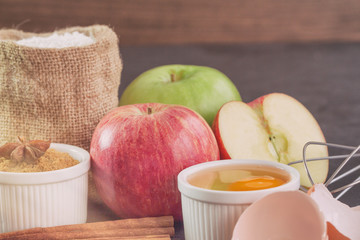 Bakery background comprise with apples,wheat flour,egg and cinnamon on granite table with copy space.Prepare ingredient for baking apple cake on granite background. Bakery background concept.
