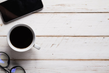 Black coffee  and smartphone. on wood background.