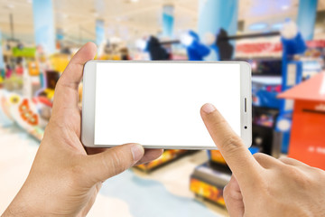 Man hand holding and using smart phone with isolated screen with blurred image of game zone in supermarket.