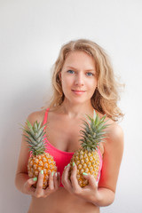 Young beautiful girl posing with fresh pineapple.Summer concept.