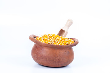 corn seed in clay pot with wood spoon on white background  ,local food in north zone