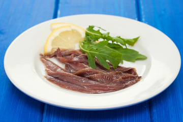 anchovies with lemon on white plate