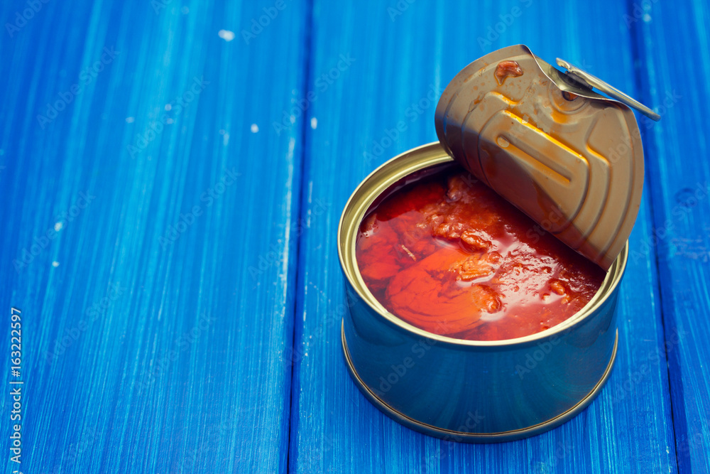 Wall mural fish with tomato in iron box on wooden background