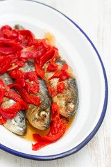 grilled sardines with red pepper on white dish