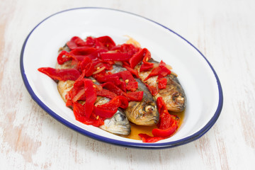 grilled sardines with red pepper on white dish
