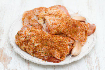 raw chicken with herbs  on white plate