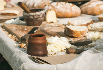Table full of bread and some dishes on it, outdoors soft sun light