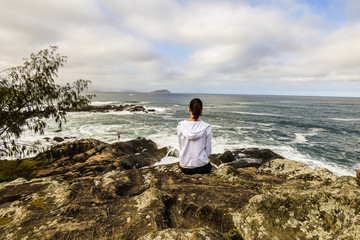 Woman alone looking at the waves in Florianopolis, Brazil