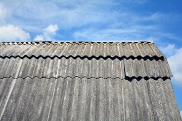 Old roof asbestos roof slates against blue sky