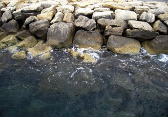 Fototapeta na wymiar Sea rocks and dark water, sea background