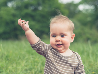 Cute little baby in nature making gesture