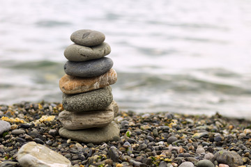 Stack of zen stones on beach. Pyramid of stones on the beach. Zen meditation background - balanced stones stack close up