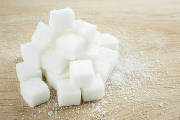 close up of white sugar cubes on wooden table.