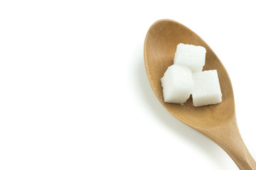 Sugar cubes in a wooden spoon on a white background.