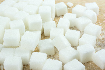 Fototapeta na wymiar close up of white sugar cubes on wooden table.