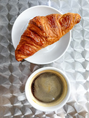 Breakfast with coffee and croissants on table