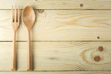 Spoon and fork wood on wooden background.