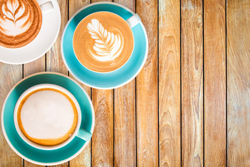 Three top view hot Coffee in cup and on Wooden table.