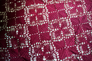 Beautiful red texture of knitted shawls. Texture of knitted white petals. Knitting stitch, shawls, plaid handmade. Maro knitting.