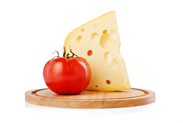 Cheese with holes ant red tomato on wooden cutting board isolated on white background