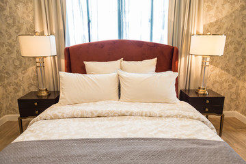 Many pillow on the bed in bedroom.