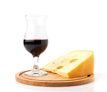 Red wine in wine glass and cheese on wooden cutting board isolated on white background