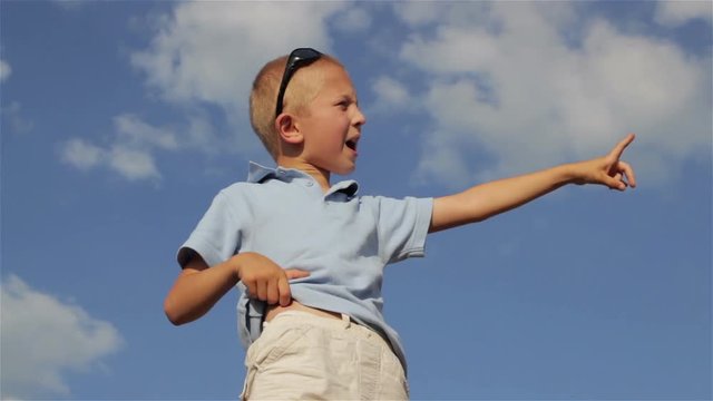 Boy pointing to the sky/In the summer boy shows a finger to the sky