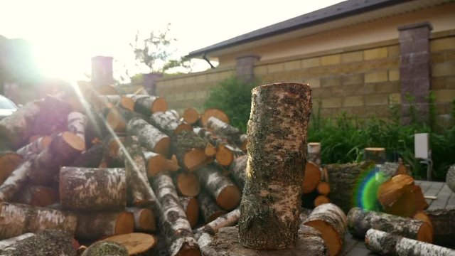 A pile of sawn firewood. Lumberjack cutting wood logs with axe, man splitting firewood for winter season.