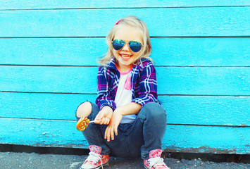 Fashion portrait happy smiling little girl child with a lollipop stick having fun