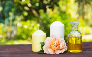 Obraz na płótnie Canvas Natural essential oil, fragrant roses and candles. Spa concept. Romantic concept. Copy space
