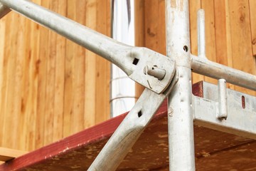 Detail of scaffolding joints at the building of a family house. Work on a building site of an ecological house.