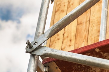 Detail of scaffolding joints at the building of a family house. Work on a building site of an ecological house.