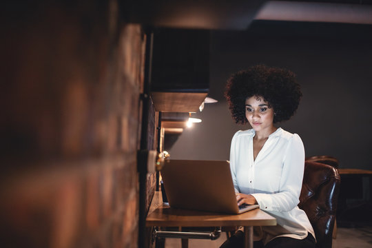 Young businesswoman working late on laptop in office