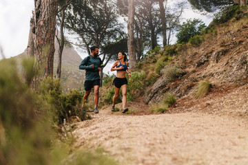 Obraz premium Young couple on cross country run in morning