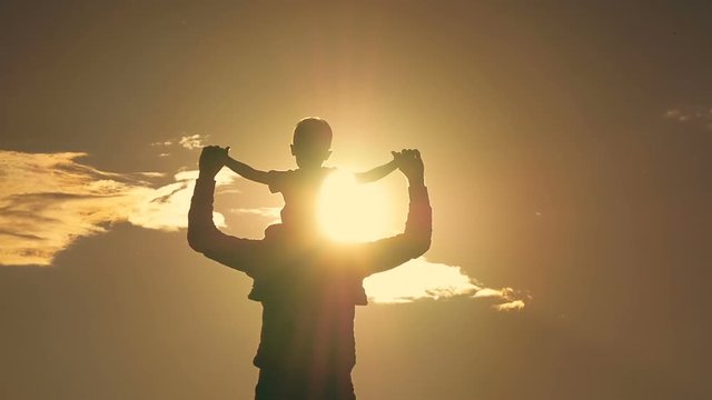 Father and son playing in the park at sunset silhouette of a happy family