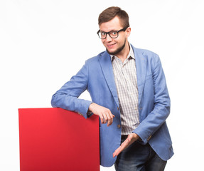 Young happy man portrait of a confident businessman showing presentation, pointing red placard, black background.Ideal for banners, registration forms, presentation, landings, presenting concept.