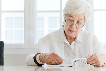 senior woman portrait, Beautiful senior woman at home, reading book