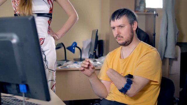 Male with the amputated arm using computer with wireless technology. 4K.