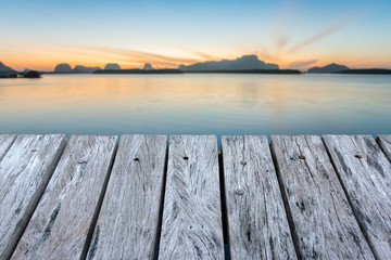 wooden table and Calm sea and beautiful sunrise.
